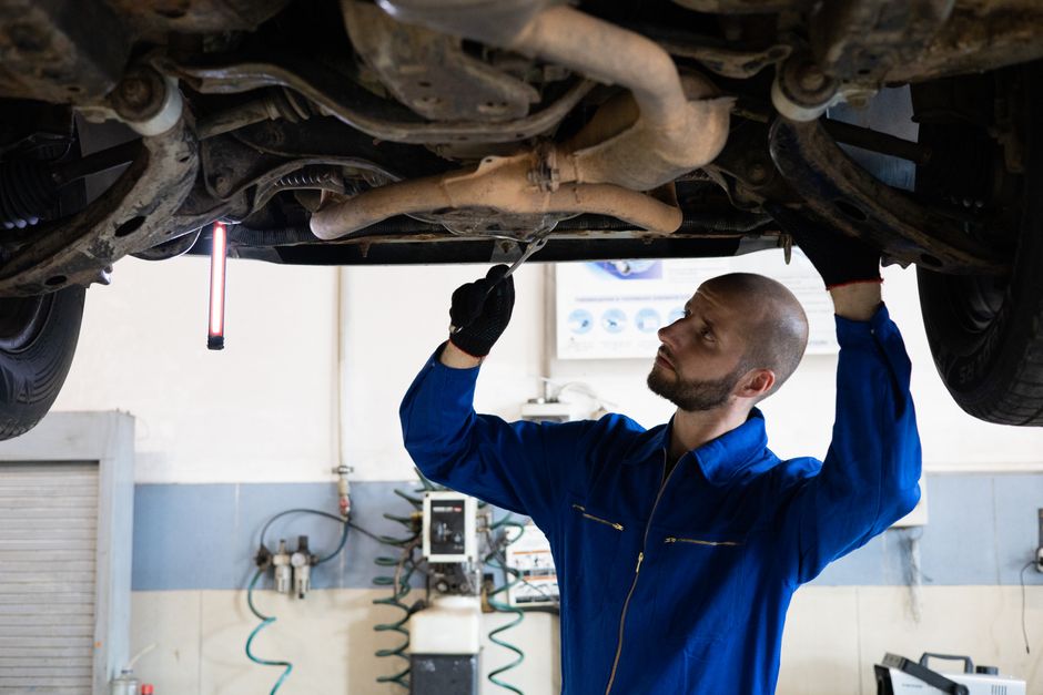 Mechanic working on a car engine in a repair shop